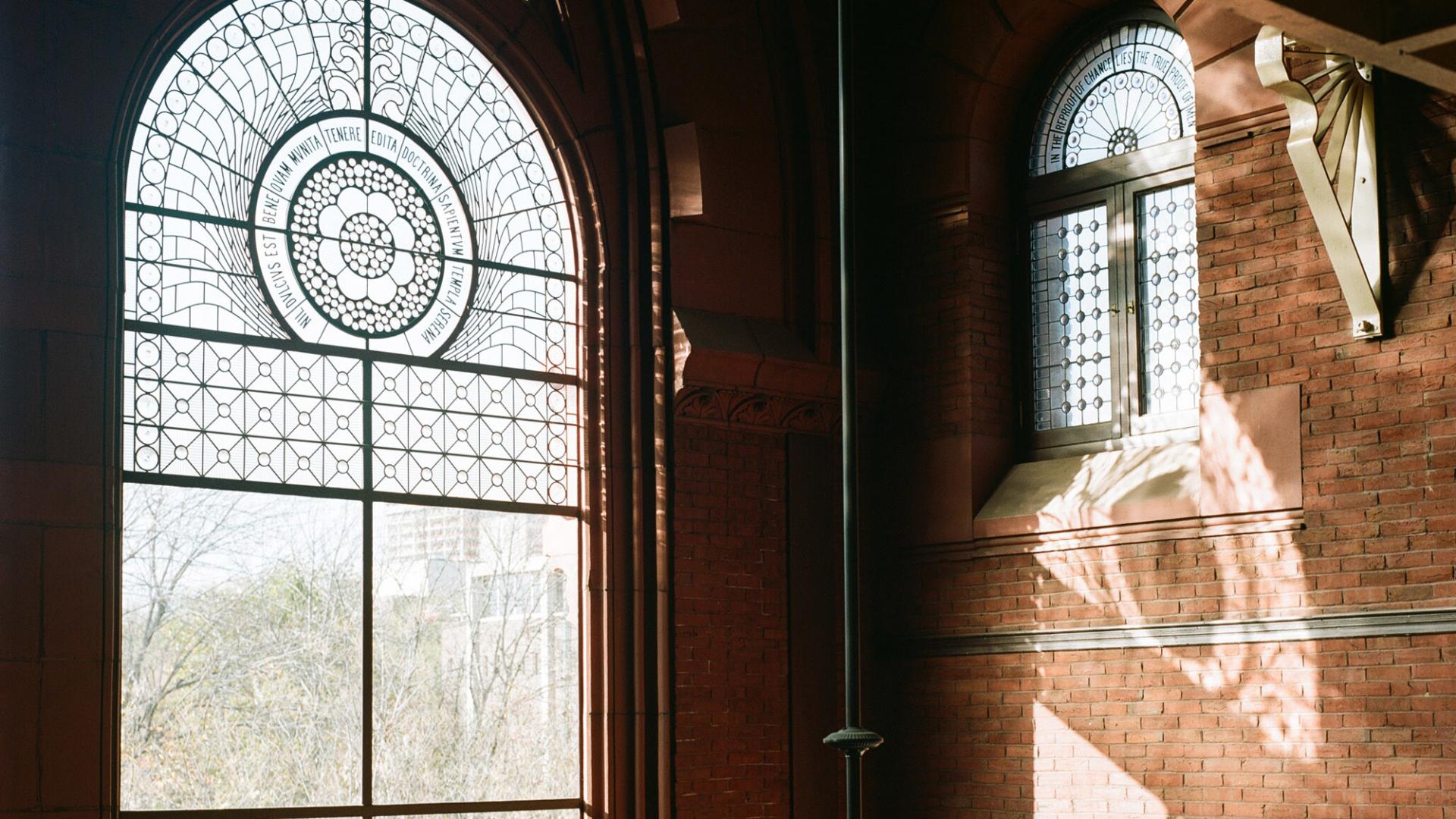 Interior shot of Library, stained glass window, brick wall