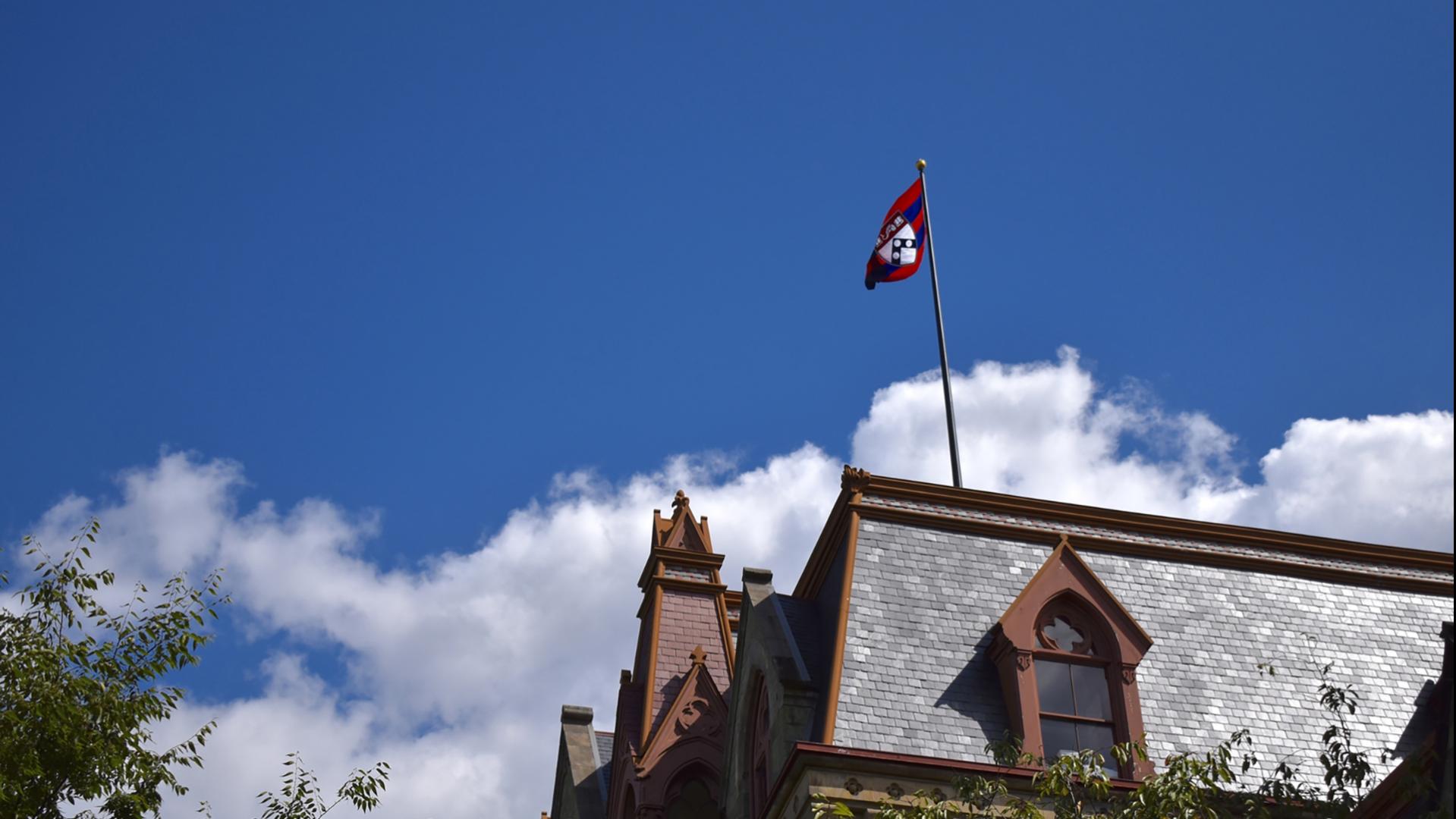 Roof of College Hall featuring the Penn flag 