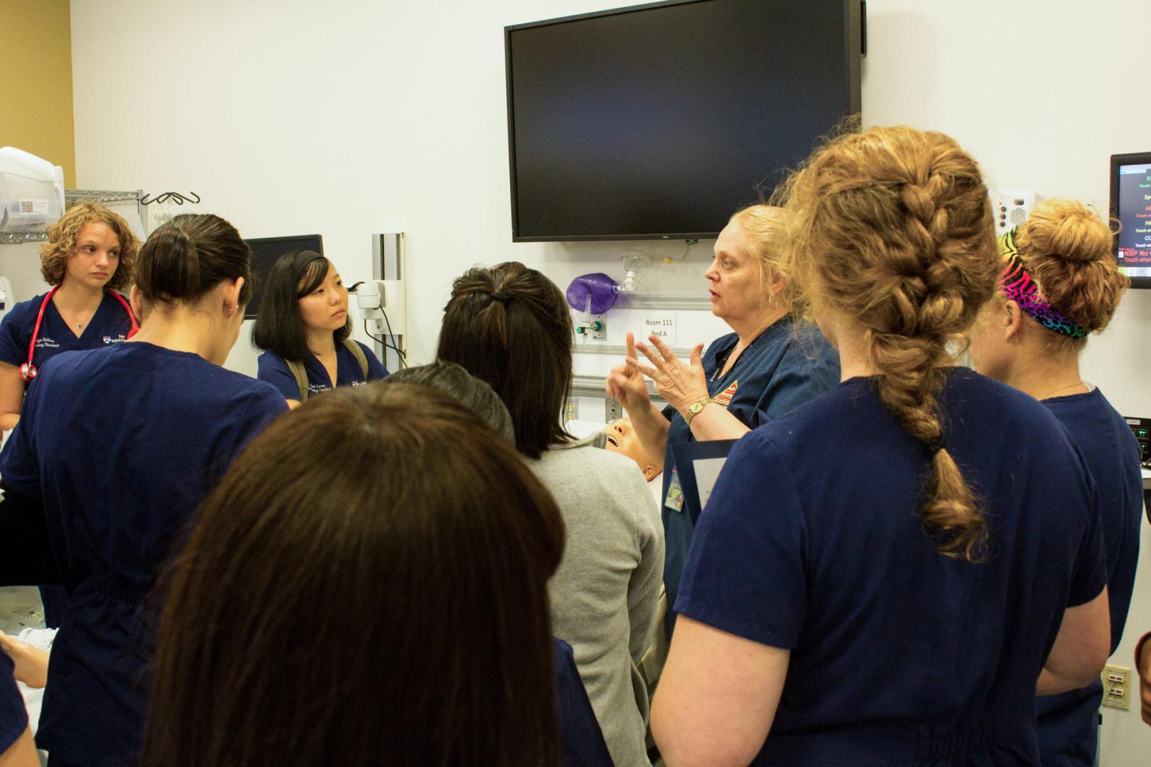 Nursing students in scrubs attending lecture 