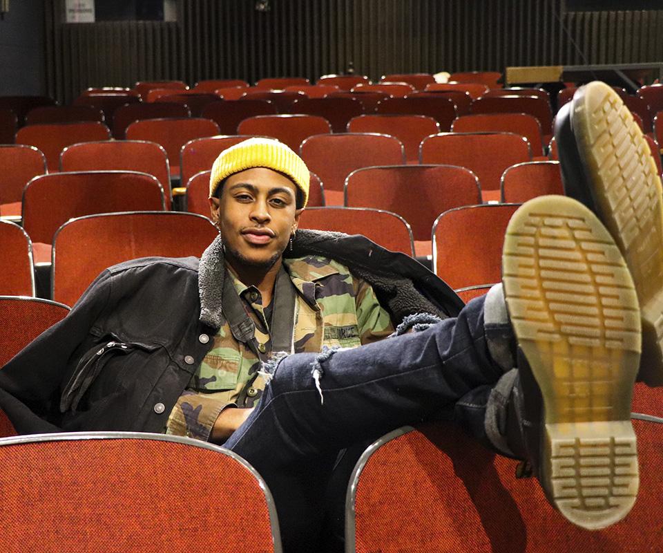 Chancelor feet up on chair in theater