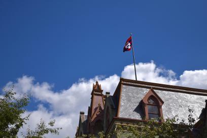 Roof of College Hall featuring the Penn flag 