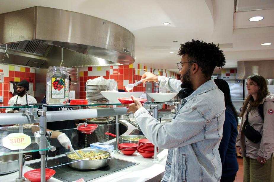 Student filling his plate at Penn Dining Hall