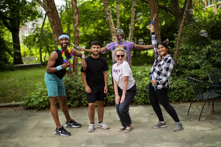 Group of five Penn LGBT students and staff celebrate Pride outside with bubbles. 