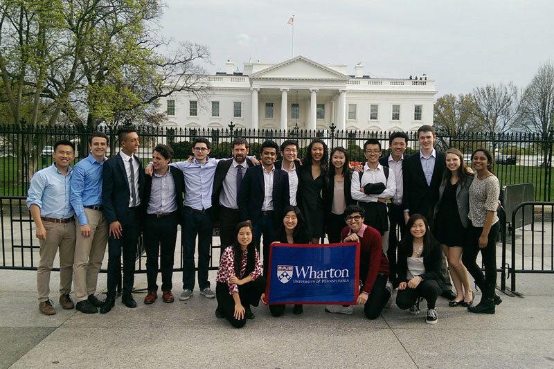 Joseph Wharton Scholars in front of the White House with a Wharton flag