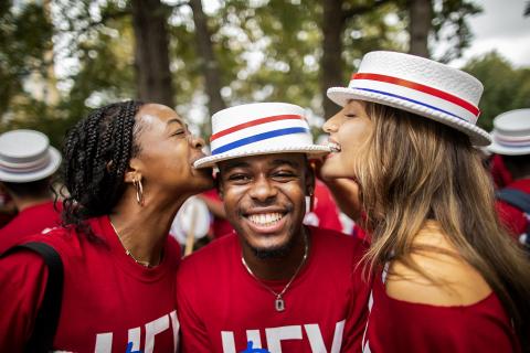 Students participating in the hat-biting tradition during Hey Day