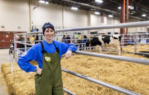 Woman standing in front of cow pens