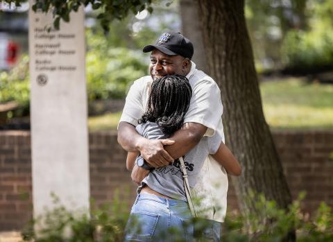 Father hugging his daughter on campus