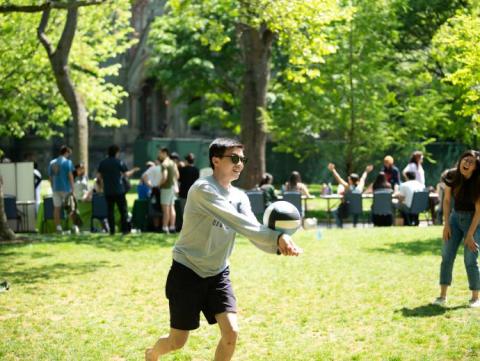 Student playing volleyball outdoors