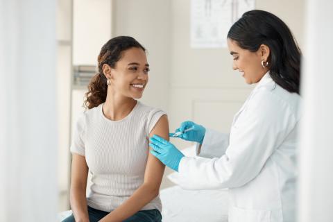 Woman getting vaccine from doctor