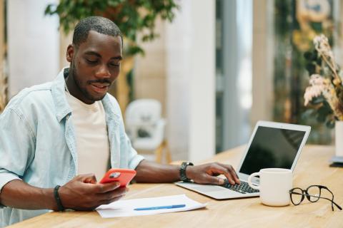 Young man with laptop and phone