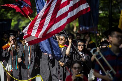 Graduates with American flag at commencement