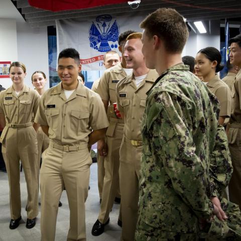 Service members in uniform stand in a group