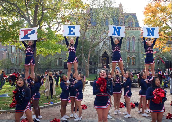 Cheerleaders holding signs to spell PENN