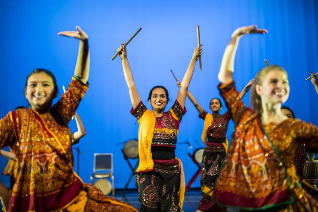 Group of Penn students are dancing on stage in sarees.