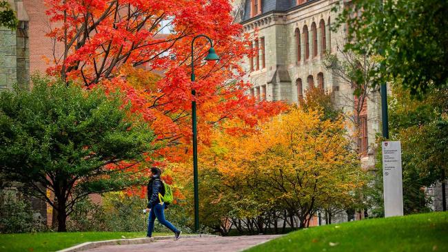 Student walking though campus in the fall
