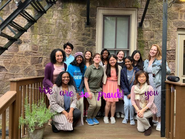 PWC students and staff standing behind a "we are so proud of you" banner on the center's patio.