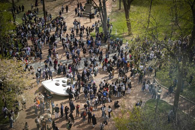 Large group of Penn students gather by the ‘Split Button’ statue on Penn campus. 