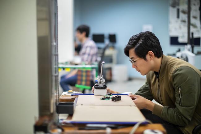 Student at desk with simple machine