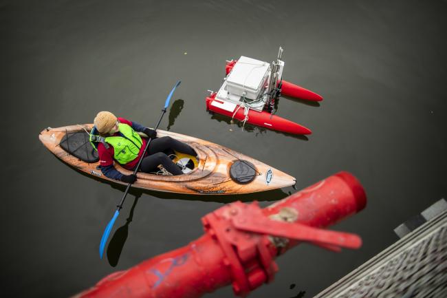 Student in kayak  deploying aquatic research