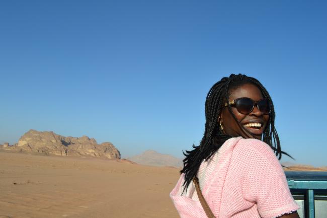 Student smiling at camera against a blue sky in the desert