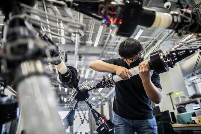 Student handling machinery in the GRASP lab