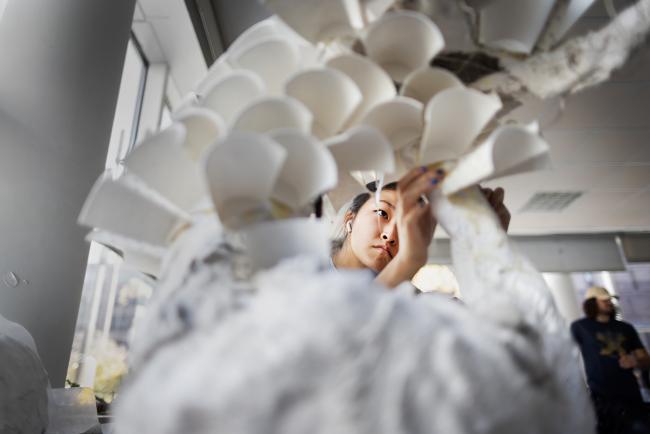 Student viewed through a paper sculpture