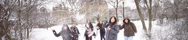 Students on campus playing in the snow.