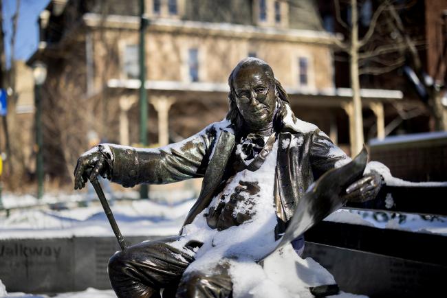 Sculpture of Benjamin Franklin dusted with snow.