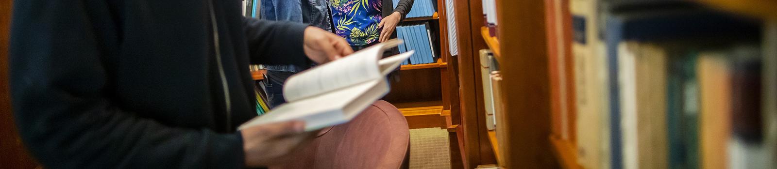 Close-up of student looking through books in Penn Library