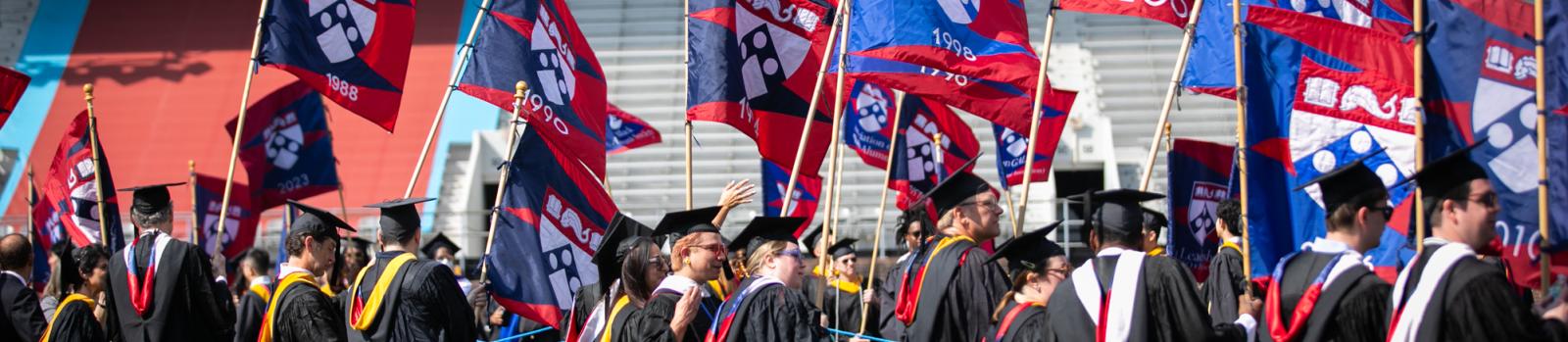 Alumni at Commencement, carrying class year flags