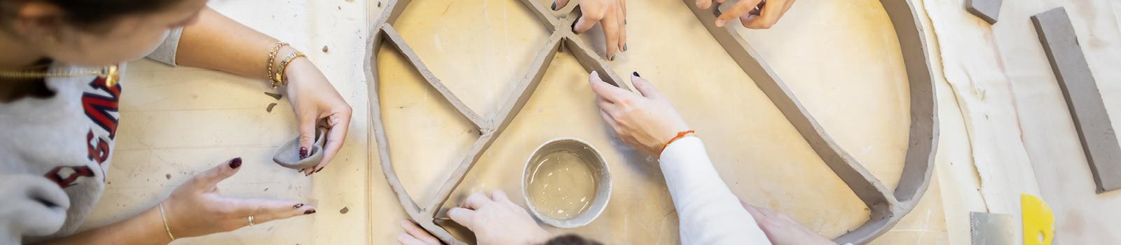 Close up of hands working with clay