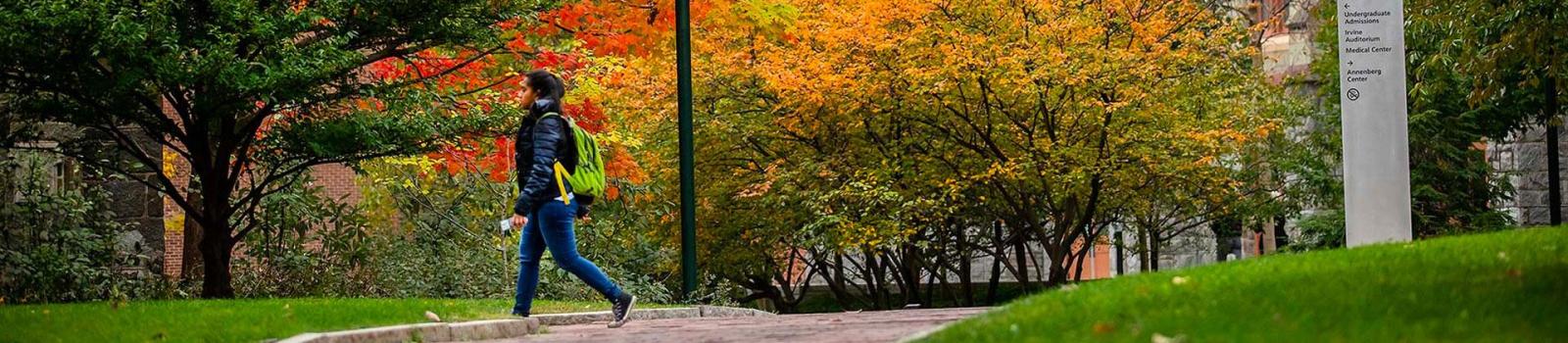 Student walking though campus in the fall