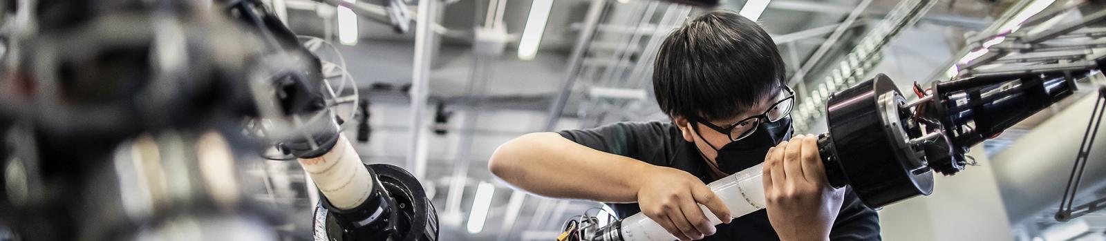 Student handling machinery in the GRASP lab