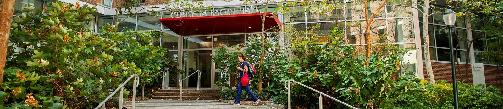 Entrance to Claire M. Fagin Hall with student walking