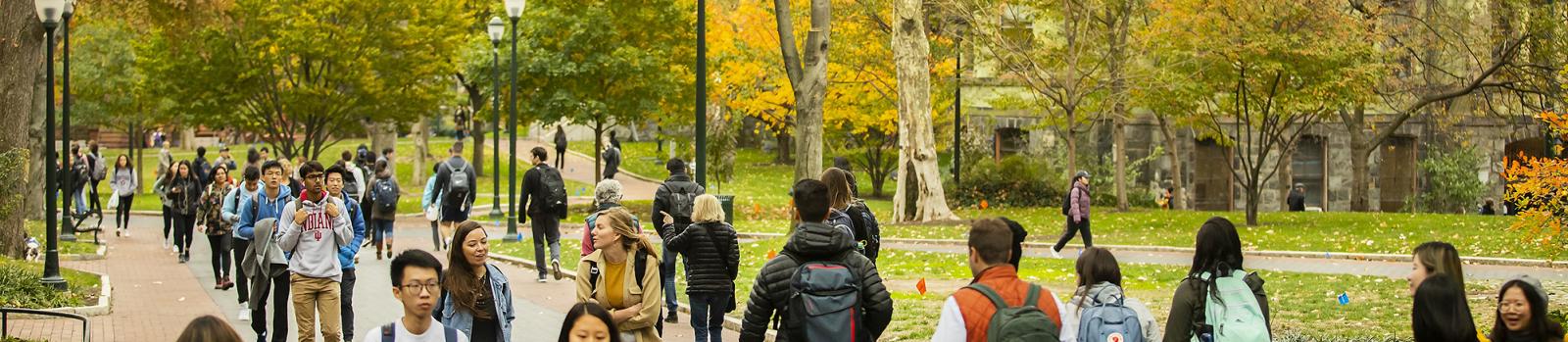 Student's walking along Penn's campus with fall foliage